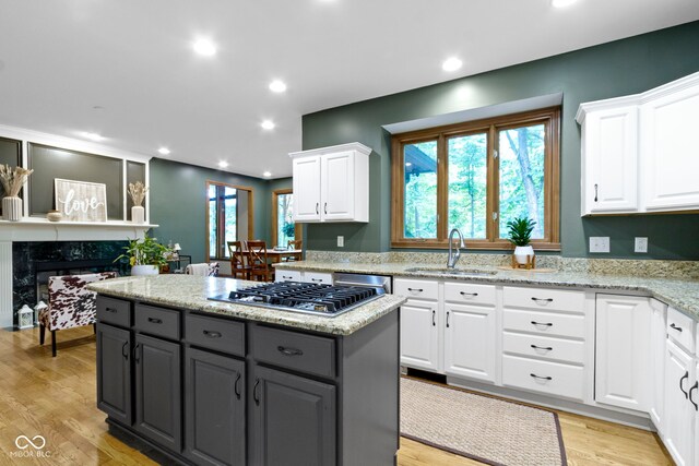 12214 Ridgeside Rd, Indianapolis, IN 46256 - kitchen featuring white cabinets, a center island, stainless steel gas cooktop, light wood finished floors, and gray cabinets