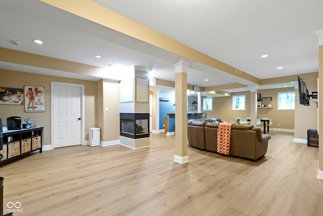 12214 Ridgeside Rd, Indianapolis, IN 46256 - living area featuring decorative columns, light wood finished floors, a tile fireplace, and recessed lighting