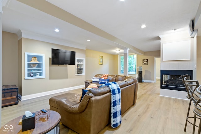 12214 Ridgeside Rd, Indianapolis, IN 46256 - living room with light wood-type flooring, ornate columns, a tile fireplace, and recessed lighting