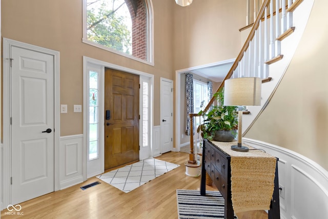 12214 Ridgeside Rd, Indianapolis, IN 46256 - entrance foyer featuring a towering ceiling, wood finished floors, a wainscoted wall, plenty of natural light, and stairway