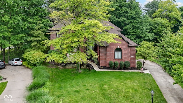 12214 Ridgeside Rd, Indianapolis, IN 46256 - view of front of property with brick siding, a front yard, and a shingled roof