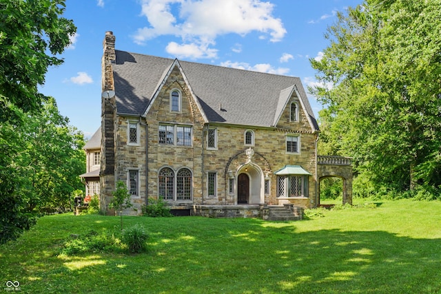 2421 W 39th St, Indianapolis, IN 46228 - tudor home featuring stone siding, a front yard, and a chimney