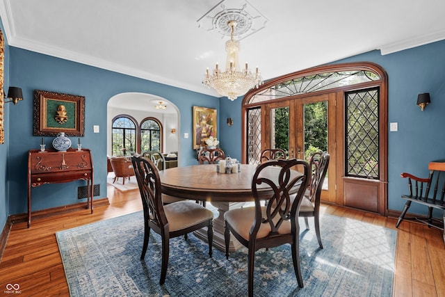 2421 W 39th St, Indianapolis, IN 46228 - dining space with arched walkways, french doors, a chandelier, hardwood / wood-style flooring, and crown molding