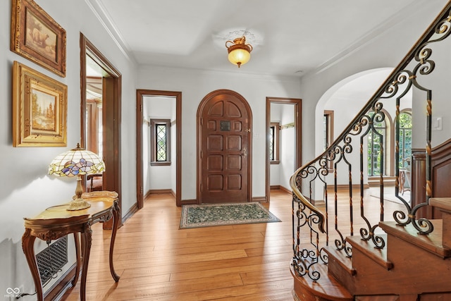 2421 W 39th St, Indianapolis, IN 46228 - entryway with arched walkways, stairway, light wood-type flooring, and crown molding