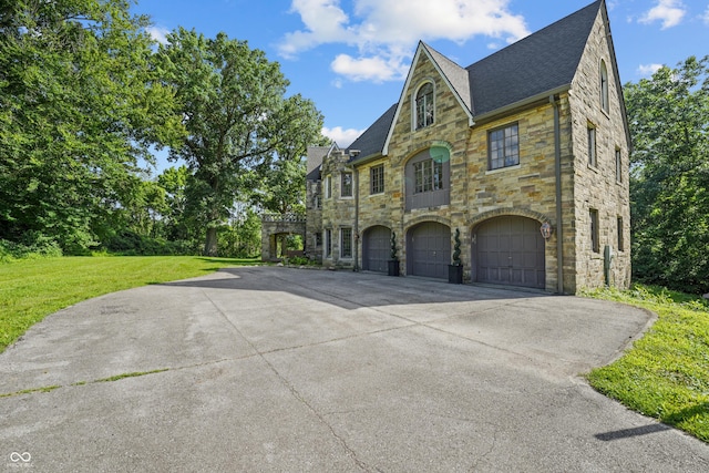 2421 W 39th St, Indianapolis, IN 46228 - view of front of home with stone siding, concrete driveway, a garage, a front yard, and roof with shingles