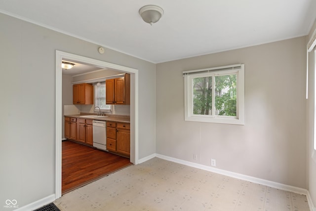 4517 E 16th St, Indianapolis, IN 46201 - kitchen featuring light floors, white dishwasher, brown cabinetry, light countertops, and ornamental molding