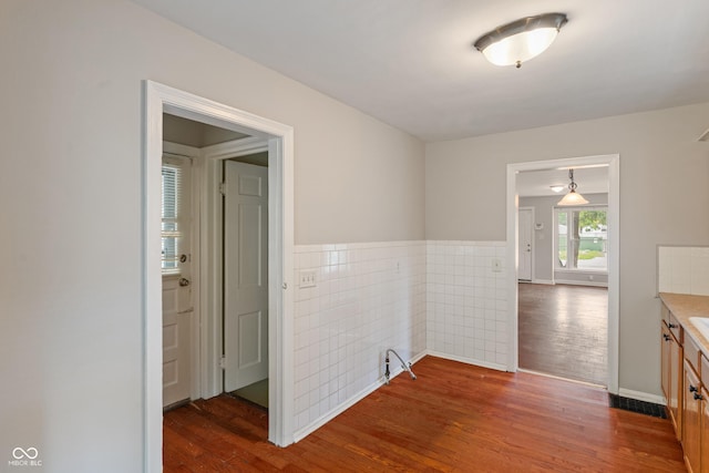 4517 E 16th St, Indianapolis, IN 46201 - hall with dark wood-style flooring, tile walls, and wainscoting