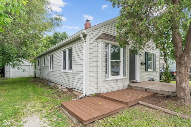 4517 E 16th St, Indianapolis, IN 46201 - view of home's exterior with a chimney, a lawn, an outbuilding, and a detached garage