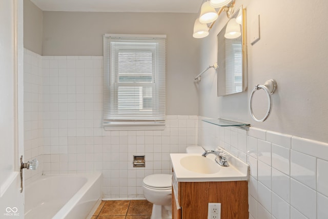 4517 E 16th St, Indianapolis, IN 46201 - bathroom with a tub to relax in, vanity, tile walls, tile patterned floors, and wainscoting