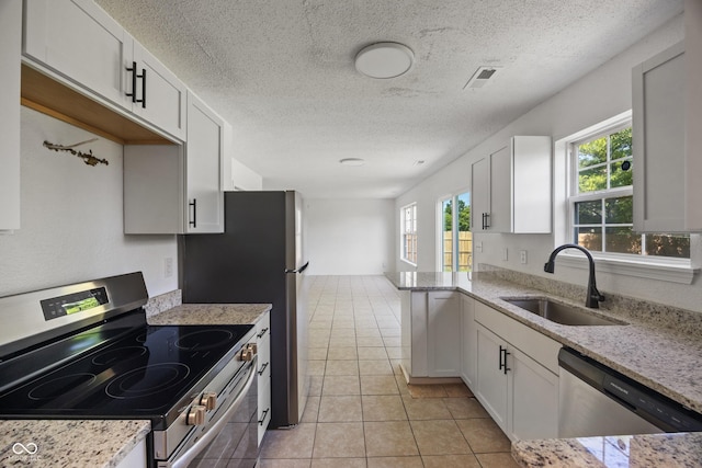 10222 Arapahoe Dr, Indianapolis, IN 46235 - kitchen featuring stainless steel appliances, a textured ceiling, light tile patterned floors, light stone counters, and white cabinetry