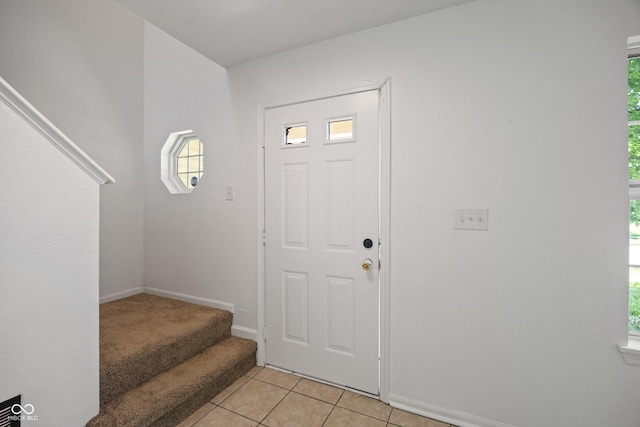 10222 Arapahoe Dr, Indianapolis, IN 46235 - foyer featuring light tile patterned floors, stairway, and healthy amount of natural light