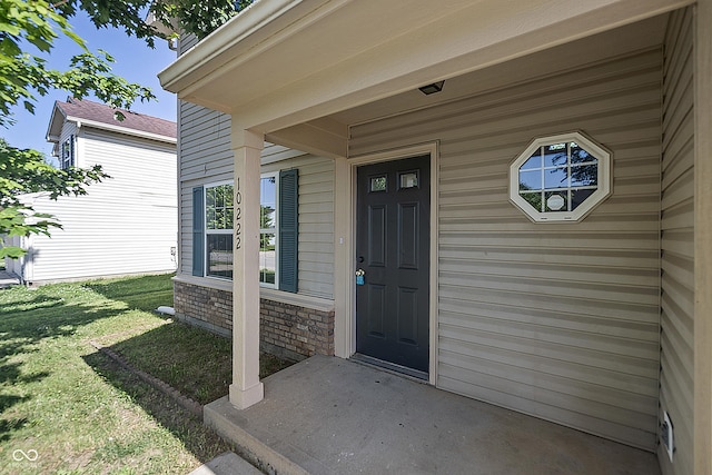 10222 Arapahoe Dr, Indianapolis, IN 46235 - property entrance with a lawn, covered porch, and stone siding