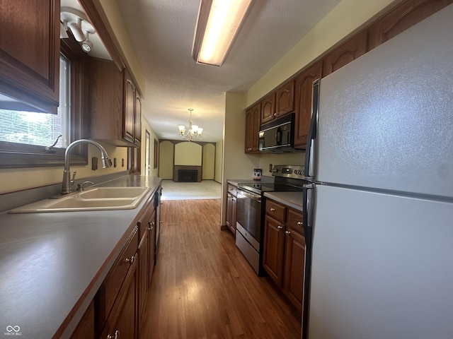 1289 Woodcreek Dr, Greenwood, IN 46142 - kitchen with freestanding refrigerator, stainless steel electric range, black microwave, a chandelier, and dark wood-style floors