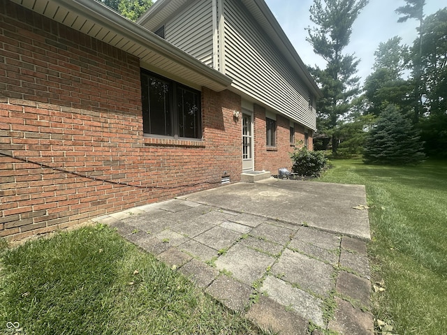 1289 Woodcreek Dr, Greenwood, IN 46142 - view of property exterior featuring a lawn, a patio area, and brick siding
