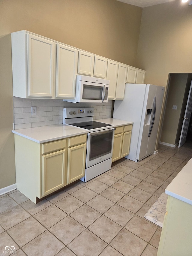 7440 Oakview Dr, Avon, IN 46123 - kitchen with white appliances, decorative backsplash, light countertops, light tile patterned floors, and a towering ceiling