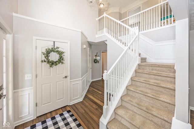 14052 Rayners Ln, Fishers, IN 46037 - foyer entrance with stairway, wood finished floors, a decorative wall, a towering ceiling, and a wainscoted wall