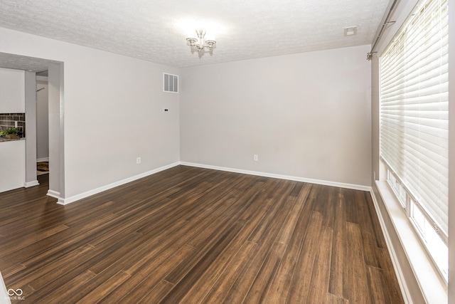 14052 Rayners Ln, Fishers, IN 46037 - spare room featuring a textured ceiling, dark wood finished floors, and a chandelier