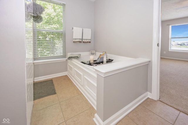 14052 Rayners Ln, Fishers, IN 46037 - bathroom featuring tile patterned flooring, a garden tub, and a textured ceiling