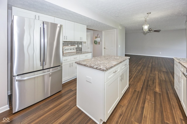 14052 Rayners Ln, Fishers, IN 46037 - kitchen with freestanding refrigerator, dark wood-type flooring, white cabinets, a kitchen island, and open floor plan