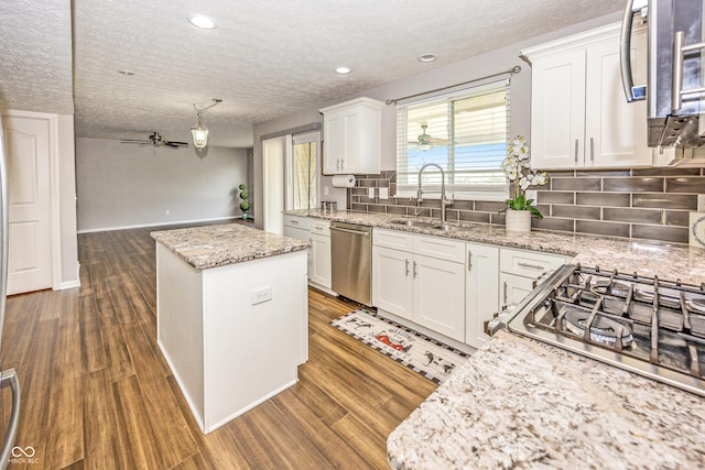 14052 Rayners Ln, Fishers, IN 46037 - kitchen with dishwasher, a textured ceiling, a ceiling fan, a kitchen island, and tasteful backsplash