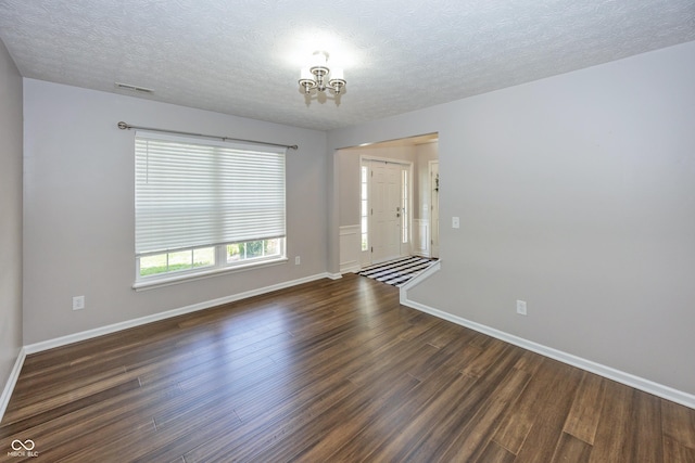 14052 Rayners Ln, Fishers, IN 46037 - unfurnished room with a chandelier, dark wood finished floors, and a textured ceiling