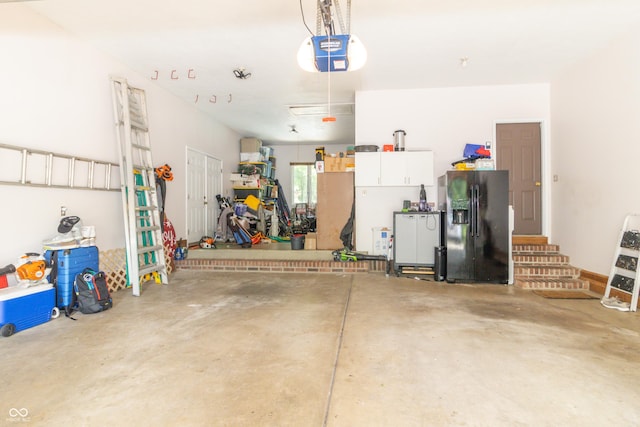 10518 Courageous Dr, Indianapolis, IN 46236 - garage with black refrigerator with ice dispenser and a garage door opener