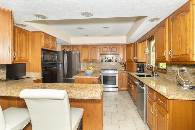 10518 Courageous Dr, Indianapolis, IN 46236 - kitchen with black appliances, a raised ceiling, a peninsula, light stone counters, and backsplash