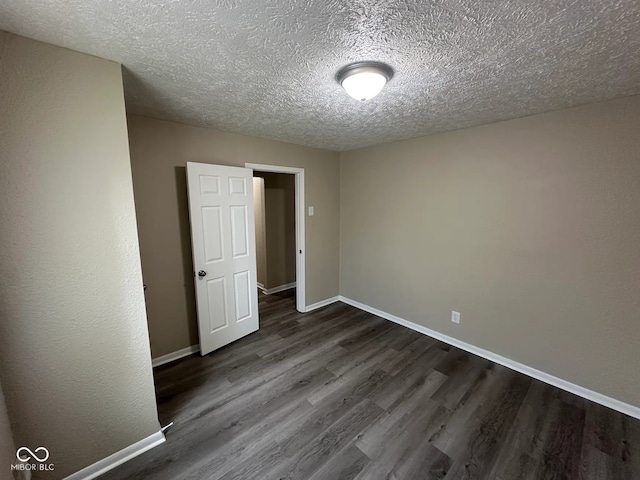115 Hugo St, Indianapolis, IN 46229 - unfurnished bedroom featuring dark wood-style flooring and a textured ceiling