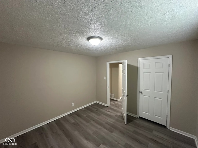 115 Hugo St, Indianapolis, IN 46229 - unfurnished bedroom featuring dark wood finished floors and a textured ceiling