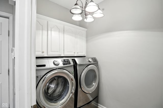 6183 Whitetail Run, Greenwood, IN 46143 - laundry room with washing machine and clothes dryer, a chandelier, and cabinet space
