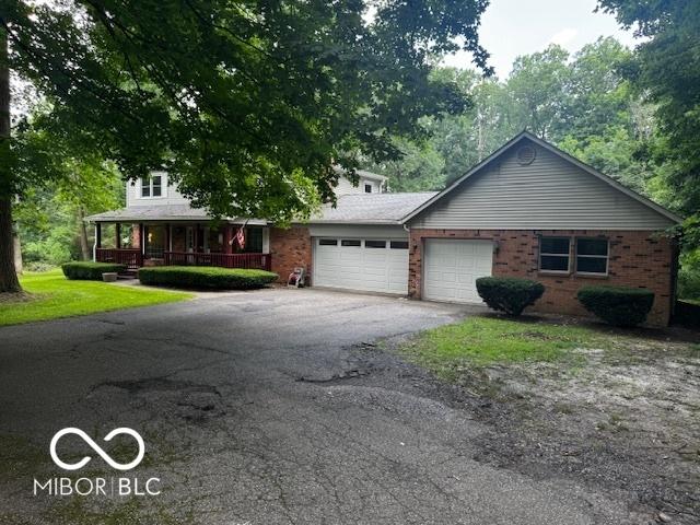 3815 Briar Rdg, Monrovia, IN 46157 - view of front facade with asphalt driveway, a garage, covered porch, and brick siding