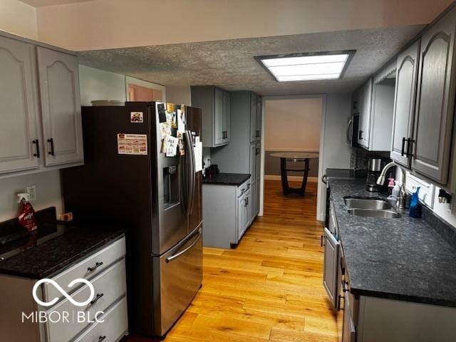 3815 Briar Rdg, Monrovia, IN 46157 - kitchen with stainless steel appliances, light wood-style floors, dark countertops, and a textured ceiling