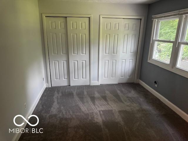 3815 Briar Rdg, Monrovia, IN 46157 - unfurnished bedroom featuring two closets and dark carpet