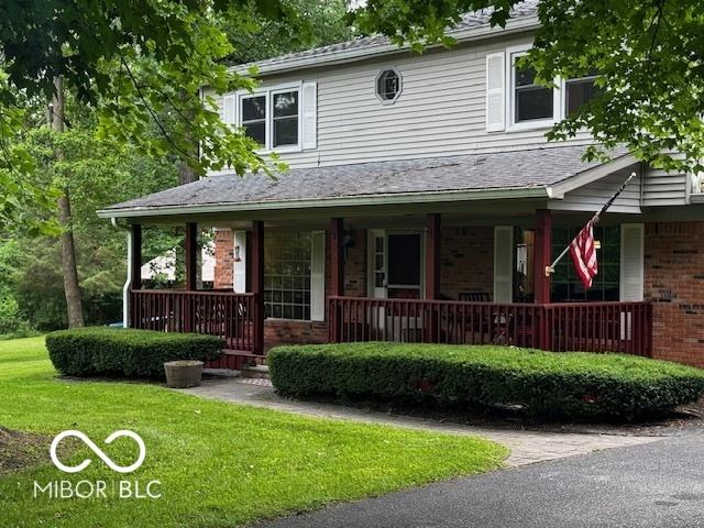 3815 Briar Rdg, Monrovia, IN 46157 - view of front of property with covered porch, brick siding, a front lawn, and roof with shingles