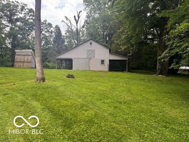 3815 Briar Rdg, Monrovia, IN 46157 - view of grassy yard featuring an outbuilding, view of wooded area, and a carport
