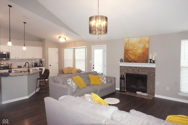 6422 Hollingsworth Dr, Indianapolis, IN 46268 - living area featuring dark wood finished floors, lofted ceiling, a chandelier, and a fireplace with flush hearth