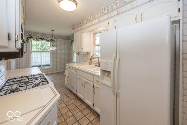 8315 Union Chapel Rd, Indianapolis, IN 46240 - kitchen with white appliances, wallpapered walls, white cabinets, light countertops, and hanging light fixtures
