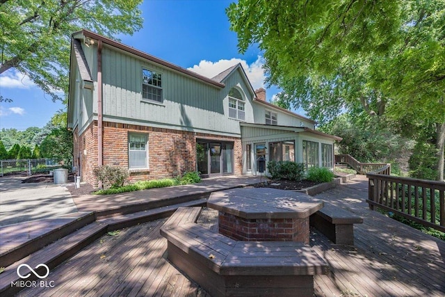 8315 Union Chapel Rd, Indianapolis, IN 46240 - back of house featuring a deck, brick siding, a sunroom, and a chimney