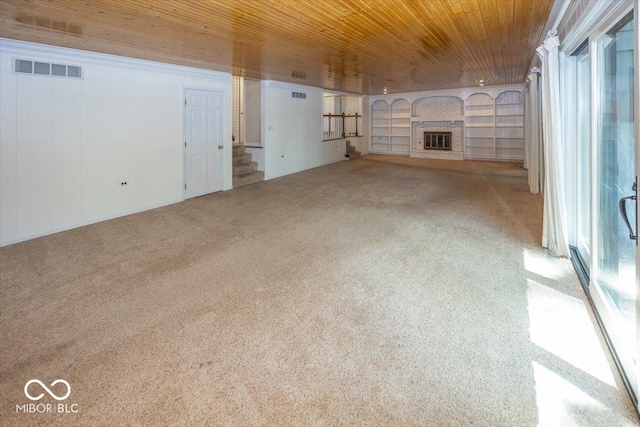 8315 Union Chapel Rd, Indianapolis, IN 46240 - unfurnished living room with carpet flooring, a brick fireplace, wood ceiling, stairs, and built in shelves