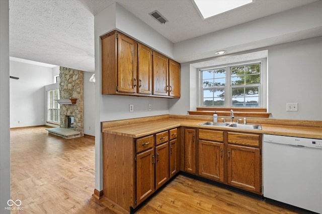 4609 Framington Ct, Indianapolis, IN 46254 - kitchen with dishwasher, light wood-style flooring, brown cabinetry, wooden counters, and a textured ceiling