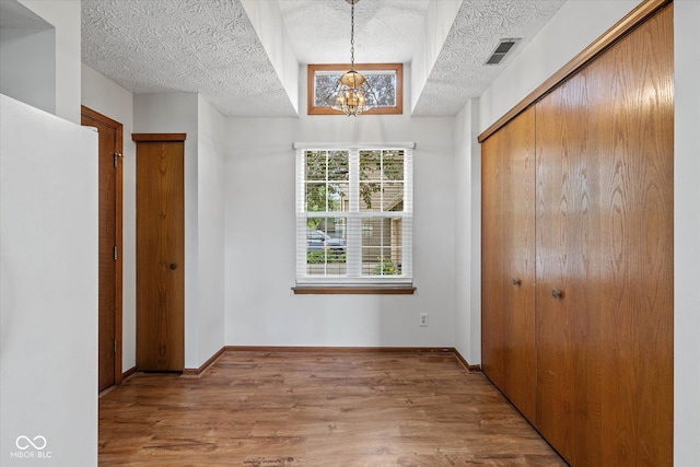 4609 Framington Ct, Indianapolis, IN 46254 - unfurnished bedroom with a chandelier, wood finished floors, and a textured ceiling