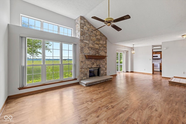 4609 Framington Ct, Indianapolis, IN 46254 - unfurnished living room featuring a ceiling fan, high vaulted ceiling, a textured ceiling, wood finished floors, and a fireplace