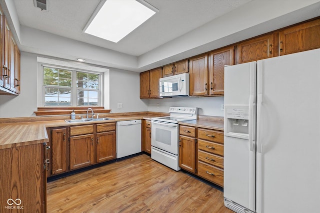 4609 Framington Ct, Indianapolis, IN 46254 - kitchen with white appliances, brown cabinetry, light wood-type flooring, butcher block counters, and a skylight