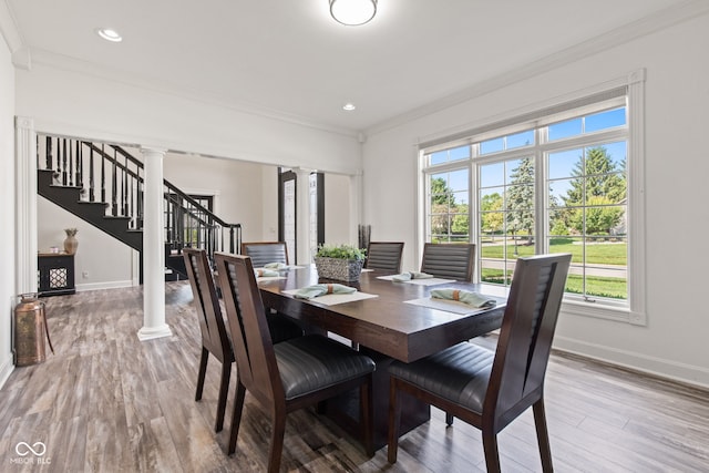 4465 W Woodbridge Ln, New Palestine, IN 46163 - dining space featuring decorative columns, stairs, ornamental molding, healthy amount of natural light, and wood finished floors
