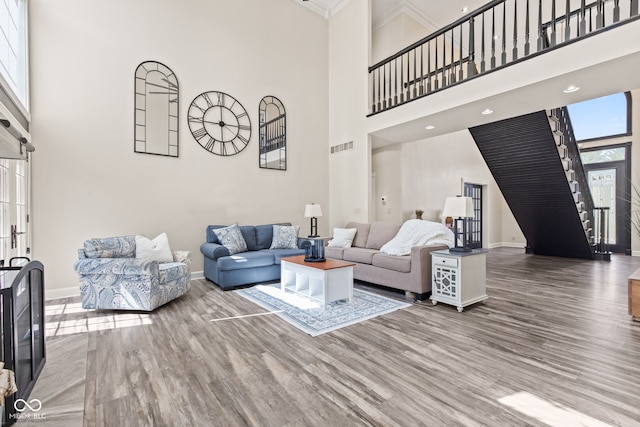 4465 W Woodbridge Ln, New Palestine, IN 46163 - living room with a high ceiling, stairway, wood finished floors, and ornamental molding