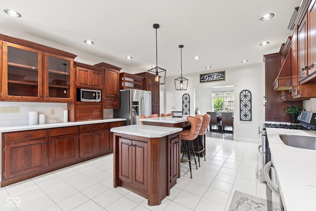 4465 W Woodbridge Ln, New Palestine, IN 46163 - kitchen featuring appliances with stainless steel finishes, light countertops, a center island, a kitchen breakfast bar, and recessed lighting