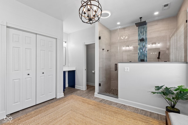 4465 W Woodbridge Ln, New Palestine, IN 46163 - bathroom featuring a chandelier, a closet, a stall shower, wood finished floors, and recessed lighting