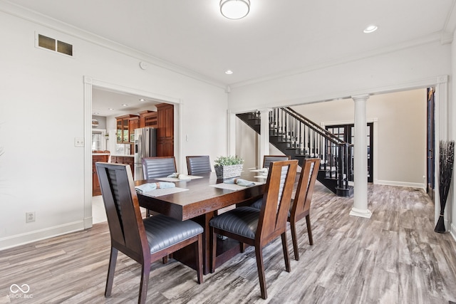 4465 W Woodbridge Ln, New Palestine, IN 46163 - dining area featuring light wood-type flooring, stairway, decorative columns, crown molding, and recessed lighting