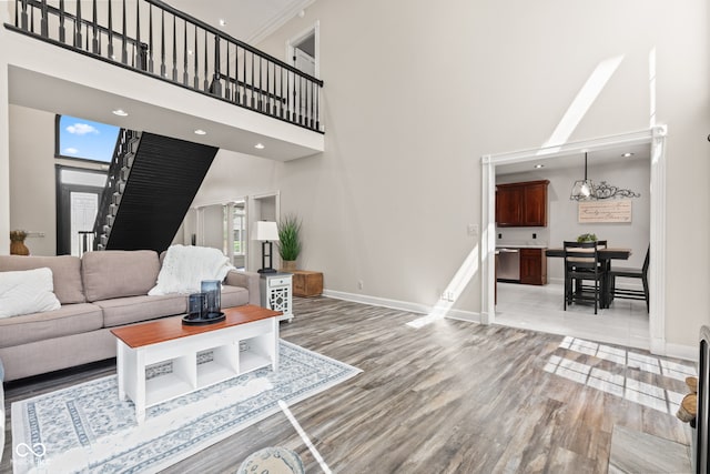 4465 W Woodbridge Ln, New Palestine, IN 46163 - living area with a towering ceiling, light wood finished floors, stairs, and recessed lighting