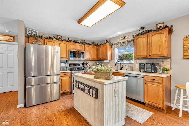 7047 Lancaster Ln, Avon, IN 46123 - kitchen featuring stainless steel appliances, light countertops, decorative backsplash, light wood-style floors, and a center island